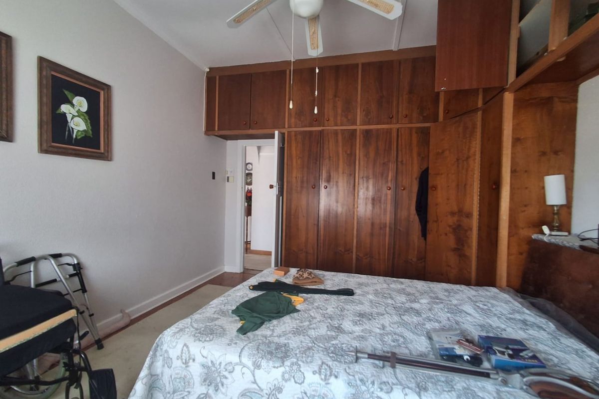 A bedroom featuring extensive built-in wooden cabinetry and a ceiling fan, offering ample storage space.