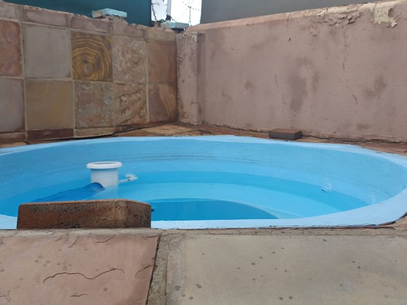 A small plunge pool area featuring stone paving and a retaining wall, currently showing signs of wear and requiring maintenance.