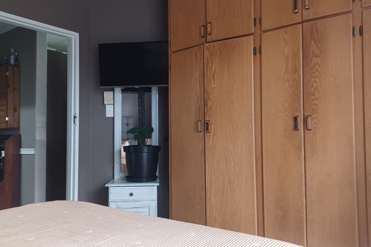 A bedroom featuring extensive built-in wooden cabinetry providing ample storage space.