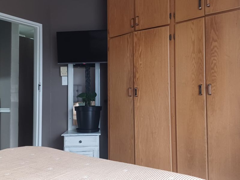 A bedroom featuring extensive built-in wooden cabinetry providing ample storage space.