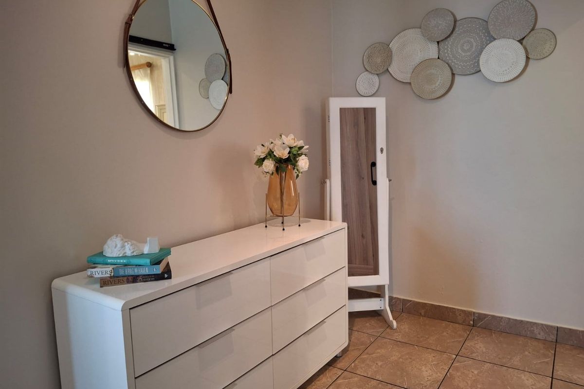 A well-maintained bedroom corner featuring neutral wall tones and durable tiled flooring, providing a clean and functional living space.