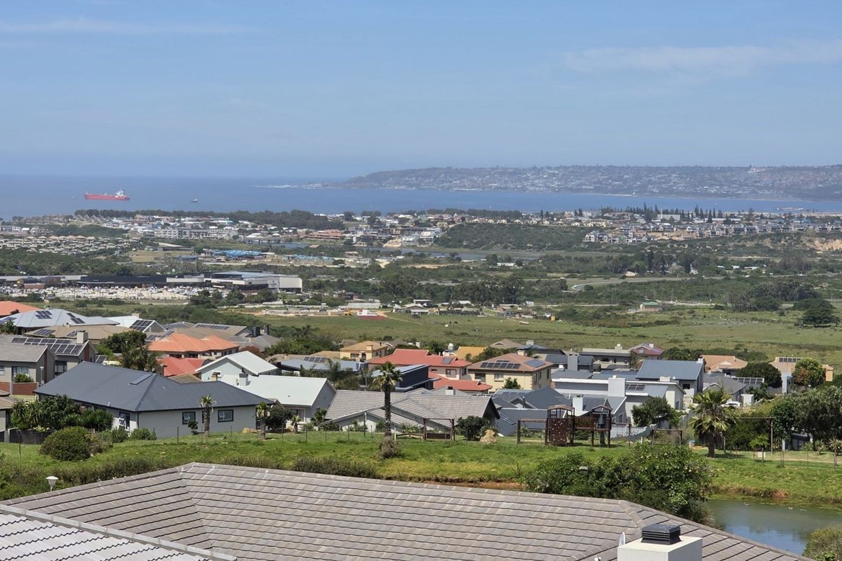 An elevated panoramic view overlooking the surrounding residential neighborhood, coastal landscape, and distant ocean horizon.