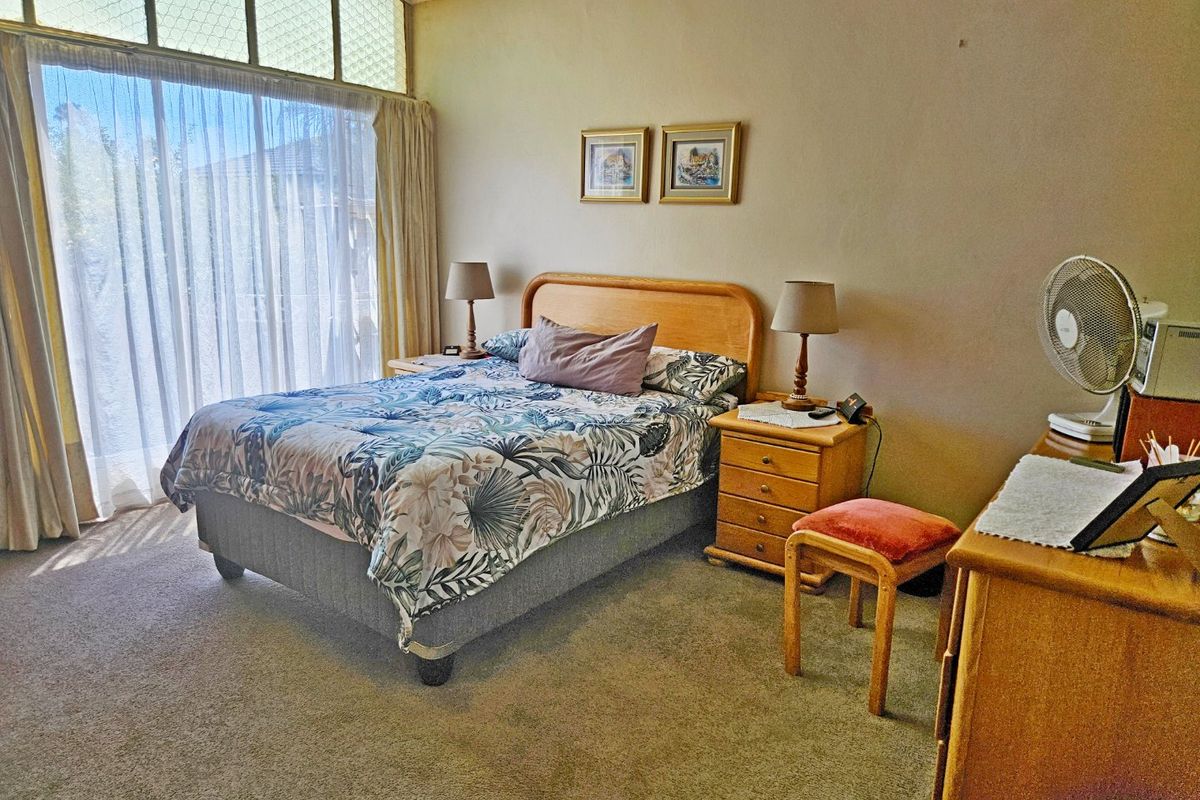 A spacious bedroom featuring large sliding glass doors and high-level clerestory windows that provide ample natural light.