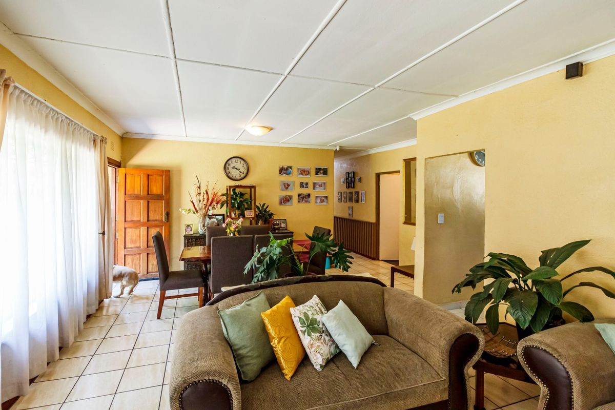 Open plan living and dining area featuring tiled flooring and a panelled ceiling, providing a functional layout with direct access to the exterior.