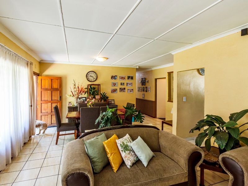 Open plan living and dining area featuring tiled flooring and a panelled ceiling, providing a functional layout with direct access to the exterior.