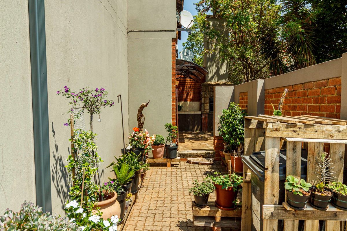 A paved rear courtyard area featuring a built-in braai and brick boundary walls, providing a functional outdoor space.