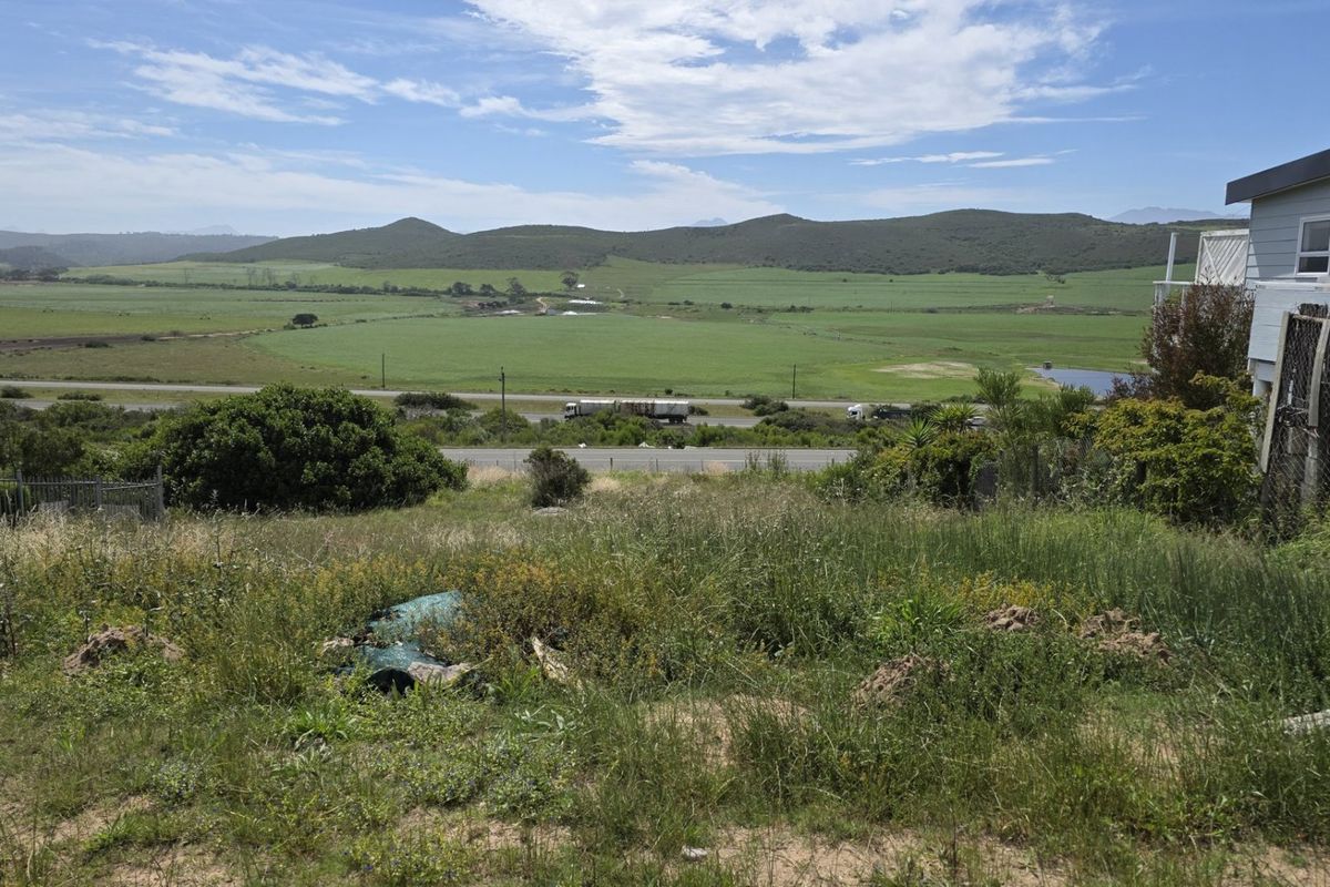 Expansive view of the surrounding rural landscape and hills from the vacant residential plot, featuring adjacent property boundary.