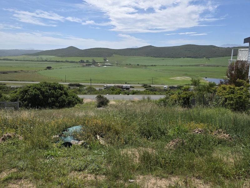 Expansive view of the surrounding rural landscape and hills from the vacant residential plot, featuring adjacent property boundary.