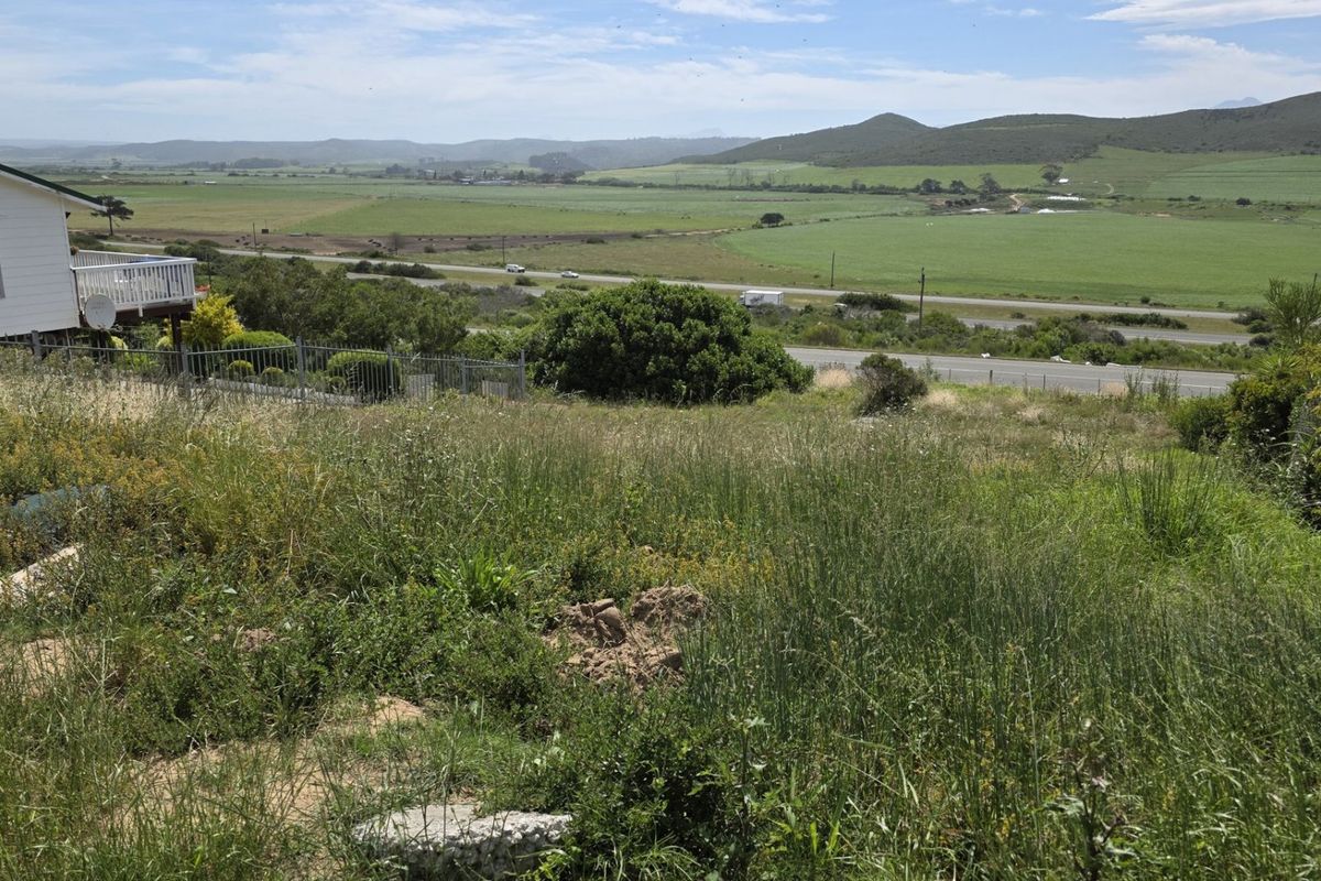 A wide-angle view of the vacant residential land featuring natural vegetation and expansive rural landscape views.
