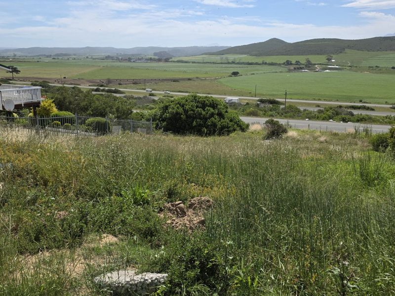 A wide-angle view of the vacant residential land featuring natural vegetation and expansive rural landscape views.