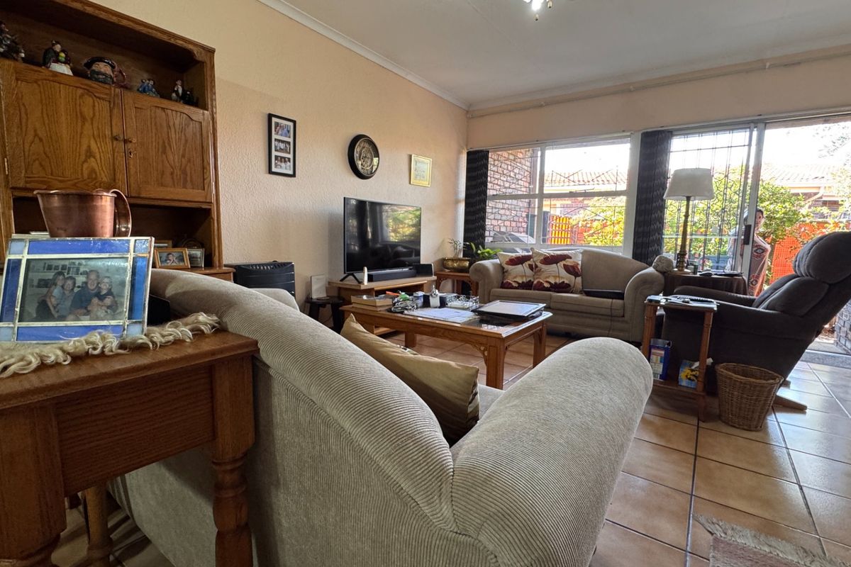 A comfortable living room featuring tiled flooring and large sliding glass doors that provide access to the outdoor area.