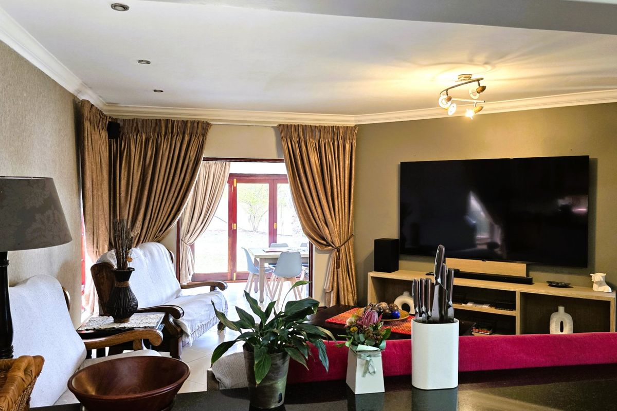 A comfortable living room featuring tiled flooring, recessed lighting, and sliding glass doors that provide access to an outdoor patio area.