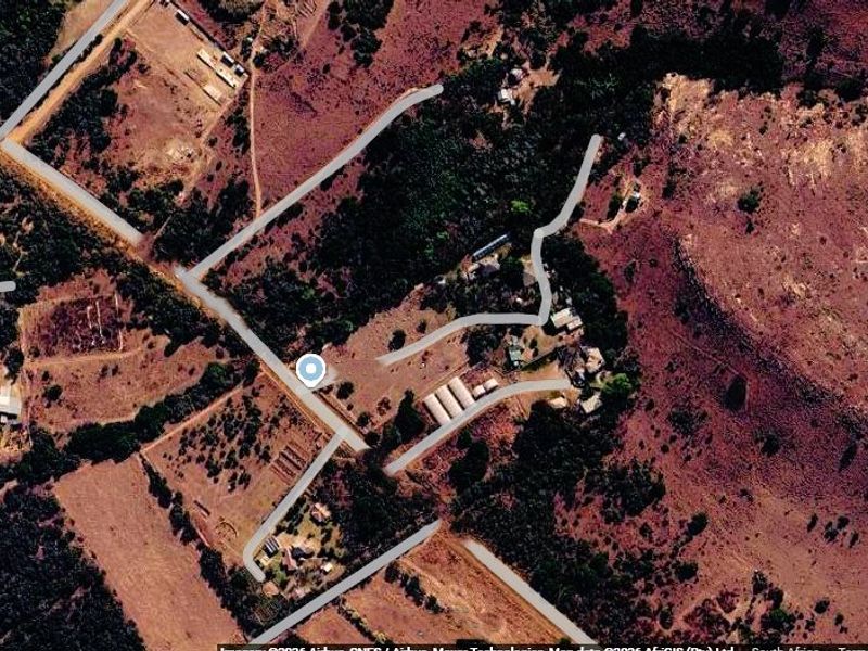 An aerial satellite view of the farm property showing the layout of access roads, existing structures, and surrounding landscape.