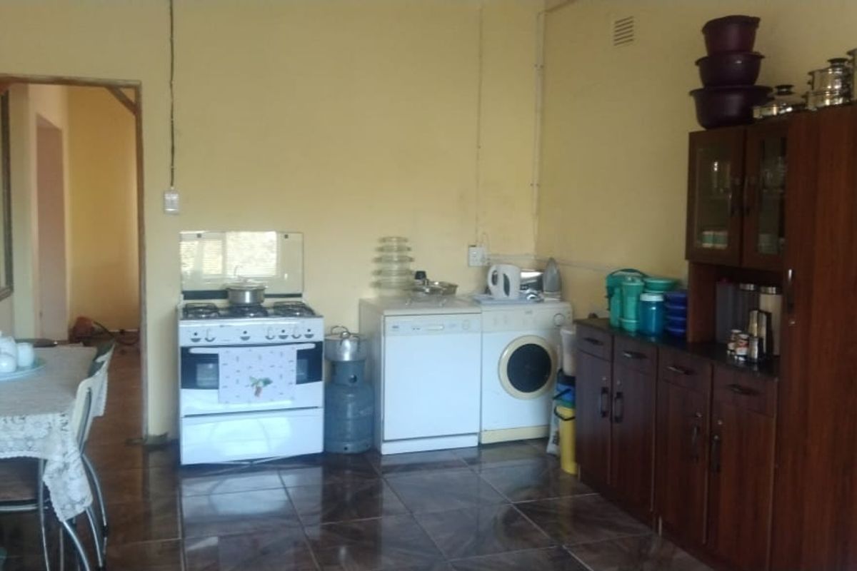 A functional kitchen area featuring tiled flooring, built-in cabinetry, and a gas stove, requiring cosmetic updates to modernize the space.