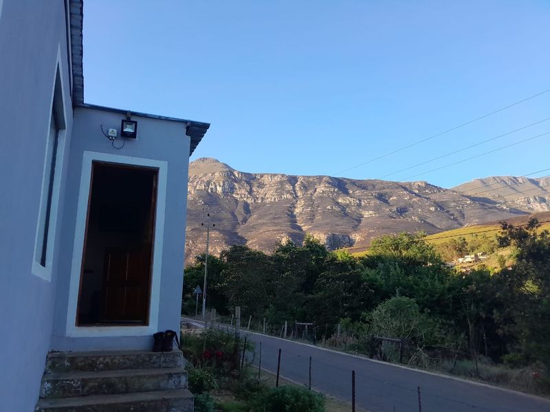 Exterior view of the property entrance featuring concrete steps and a scenic mountain backdrop.