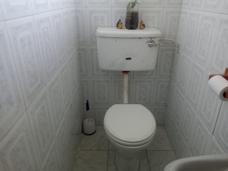 A compact bathroom featuring tiled walls and flooring with a standard toilet suite.