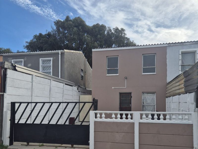 Front elevation of a two-story residential property featuring a gated entrance, precast boundary wall, and tiled roof structure.