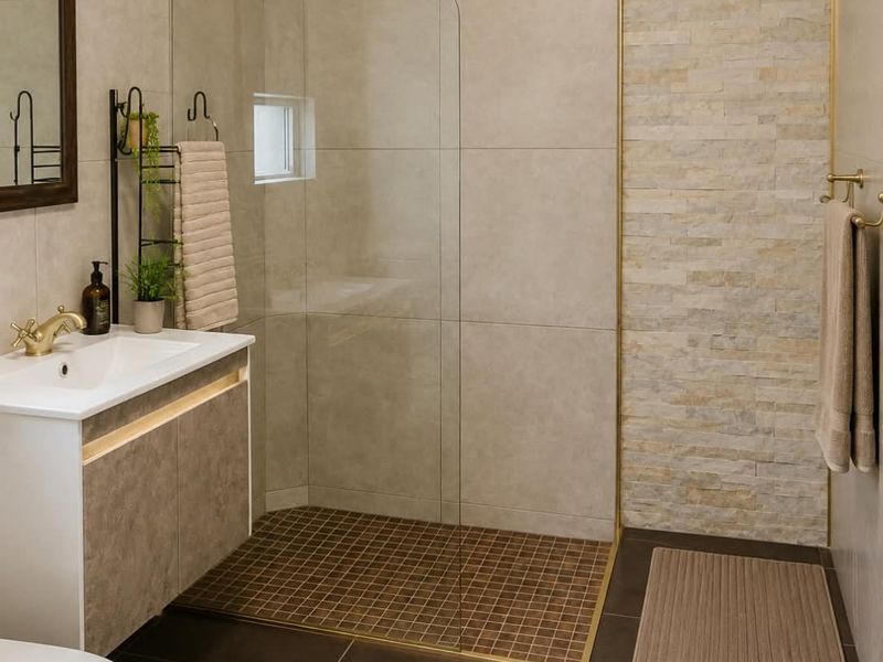 Modern bathroom featuring a walk-in shower with brass fixtures, a stone feature wall, and a contemporary vanity unit with integrated basin.