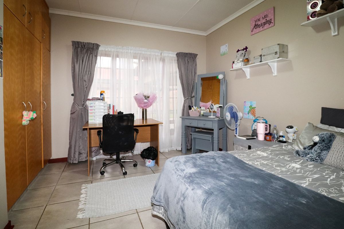 A functional bedroom featuring tiled flooring and a built-in wardrobe, offering a practical layout with natural light from the window.