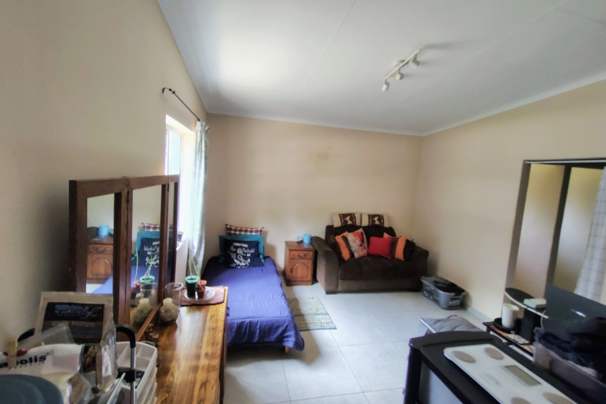 A functional bedroom featuring tiled flooring and track lighting, offering a neutral base ready for personalization or updated interior design.