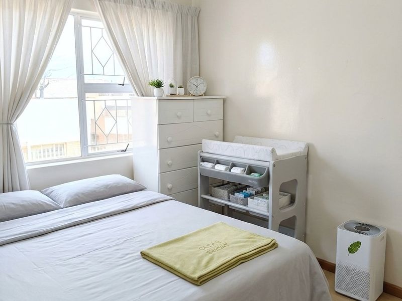 A well-maintained bedroom featuring light-toned laminate flooring, neutral walls, and a window fitted with security bars for added safety.