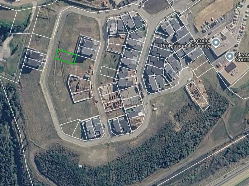 Aerial view of a vacant residential land plot within a developed estate, showing surrounding infrastructure and property boundaries.