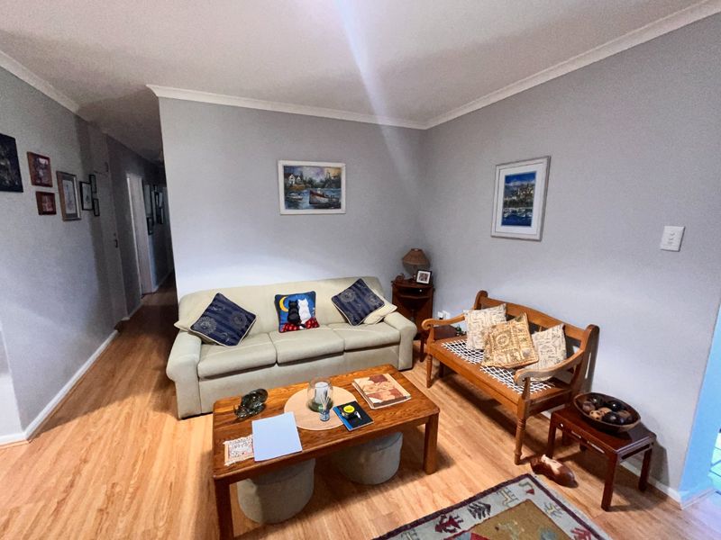 A comfortable living room featuring light-toned laminate flooring and neutral wall finishes, providing a functional and inviting space for relaxation.
