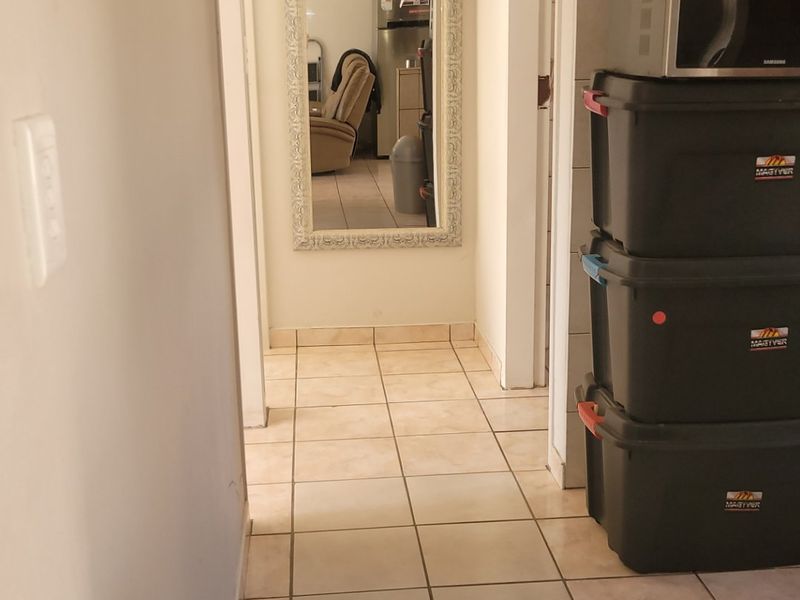A functional hallway featuring tiled flooring and built-in cabinetry, providing a clean transition between living spaces.