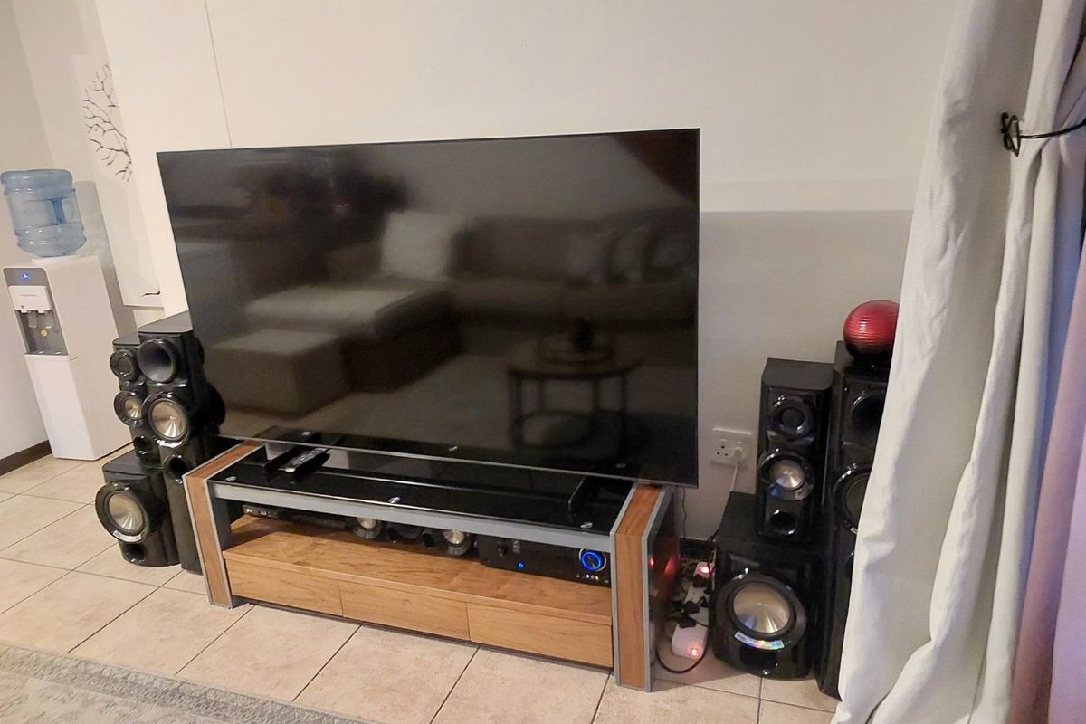 A living room area featuring tiled flooring, currently set up as a media space.