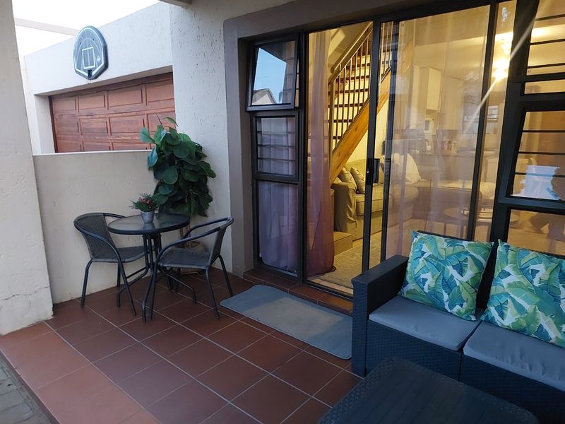 A covered patio area featuring tiled flooring and large sliding glass doors providing access to the interior living space.