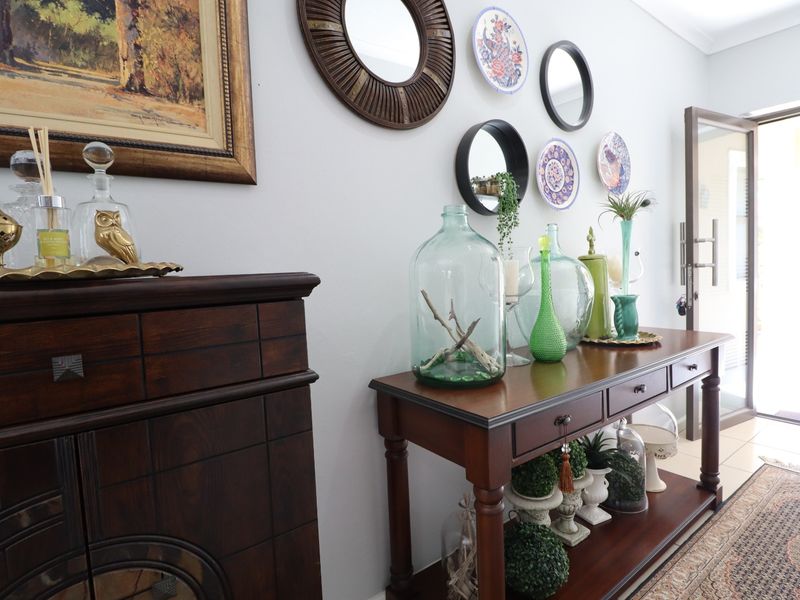 A bright and welcoming entrance hall featuring tiled flooring and a glass panel door leading to the exterior.