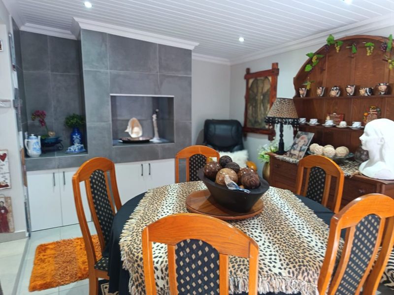 Dining area featuring a built-in fireplace with a modern tiled surround, tongue and groove ceiling paneling, and tiled flooring.