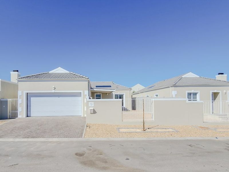 Front elevation of a modern residential property featuring a paved driveway, single garage, and clean neutral exterior finishes.