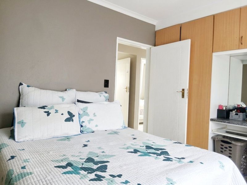 A bedroom featuring built-in wooden cupboards and an integrated vanity area, providing functional storage and dressing space.