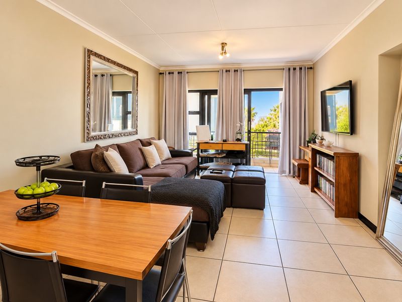 Spacious open-plan living and dining area featuring tiled flooring and direct access to a private balcony through large sliding glass doors.