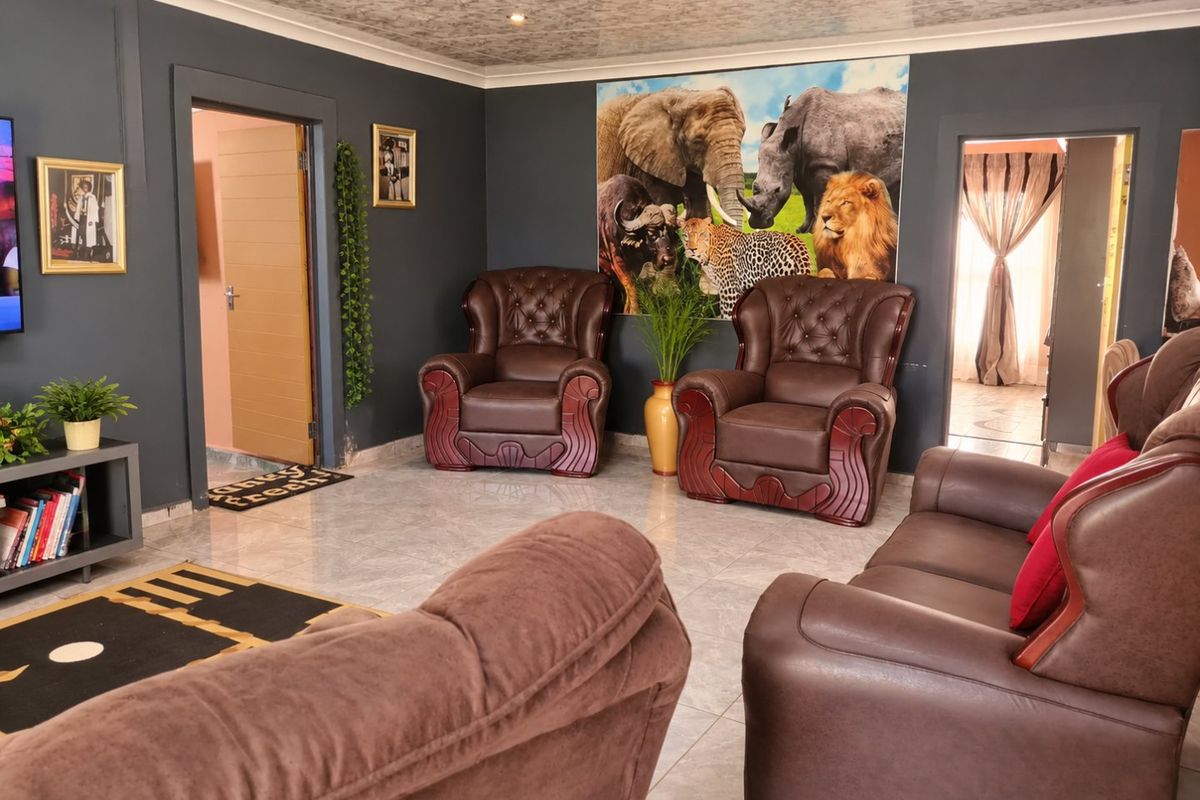 A living room featuring dark painted walls, tiled flooring, and recessed ceiling lighting with coved detailing.