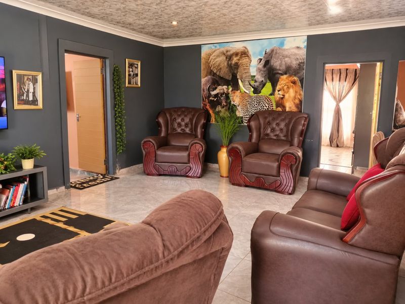 A living room featuring dark painted walls, tiled flooring, and recessed ceiling lighting with coved detailing.