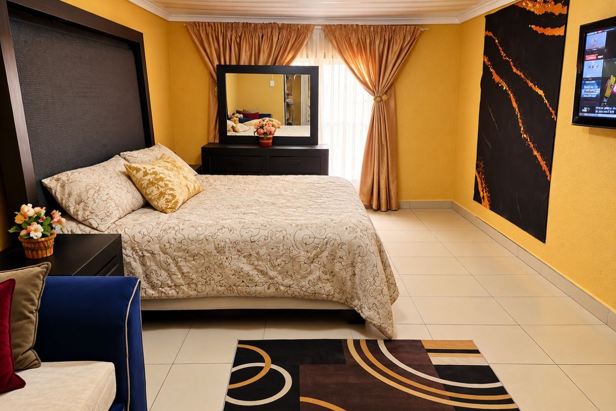 A spacious bedroom featuring tiled flooring and neutral wall finishes, offering a comfortable layout with ample natural light.