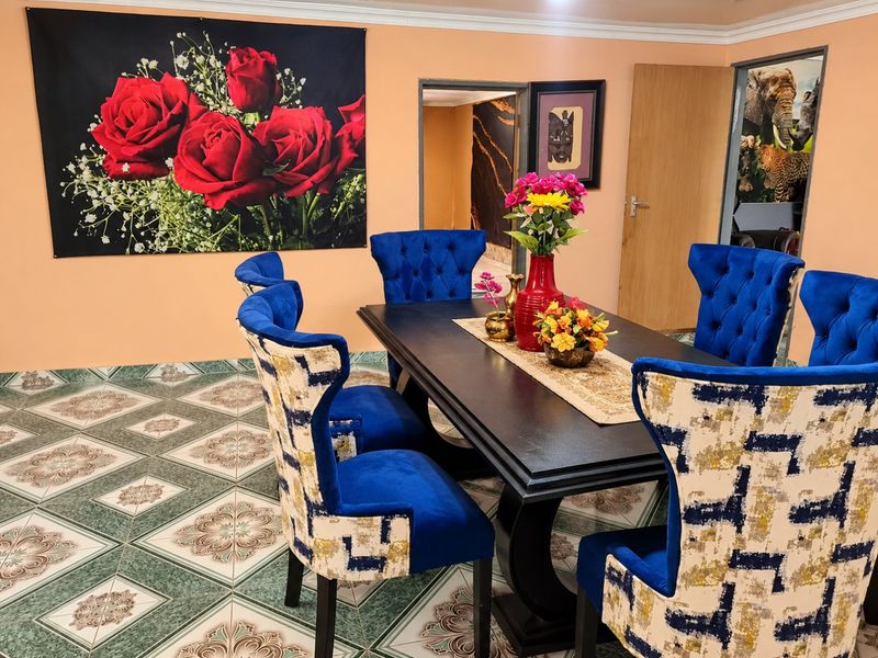 A dining room featuring patterned ceramic floor tiles and coved ceiling cornicing, providing a functional space for family meals.
