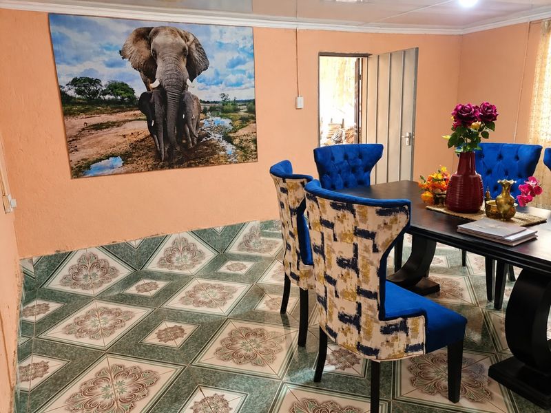 A dining room featuring patterned ceramic floor tiles and peach-toned walls, providing a functional space for family meals.
