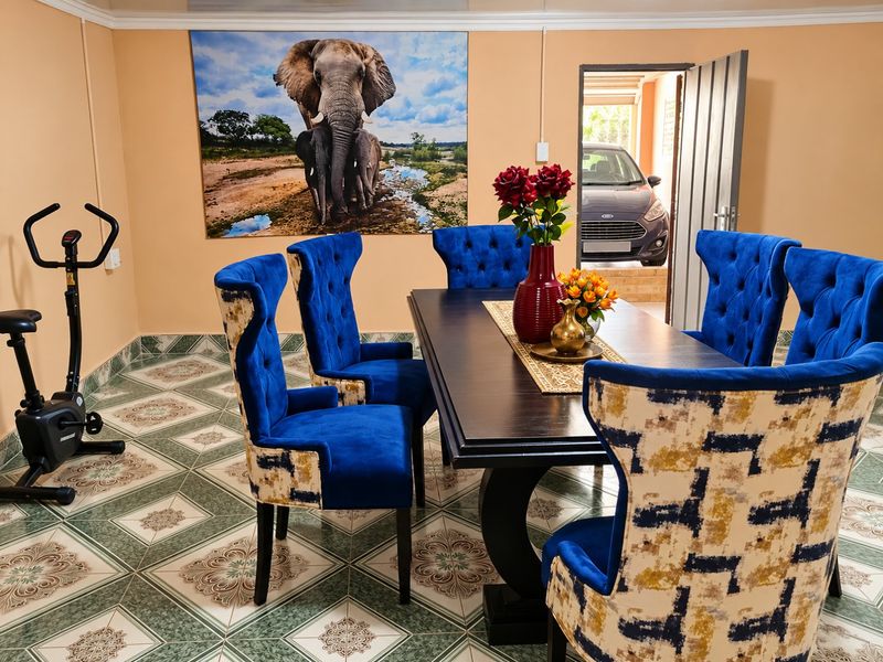 A dining area featuring patterned ceramic floor tiles and coved ceiling cornicing, with direct access to an adjacent garage space.