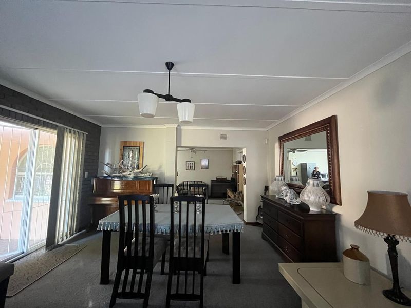Dining room featuring an exposed brick wall, sliding glass door access to the patio, and neutral wall finishes.