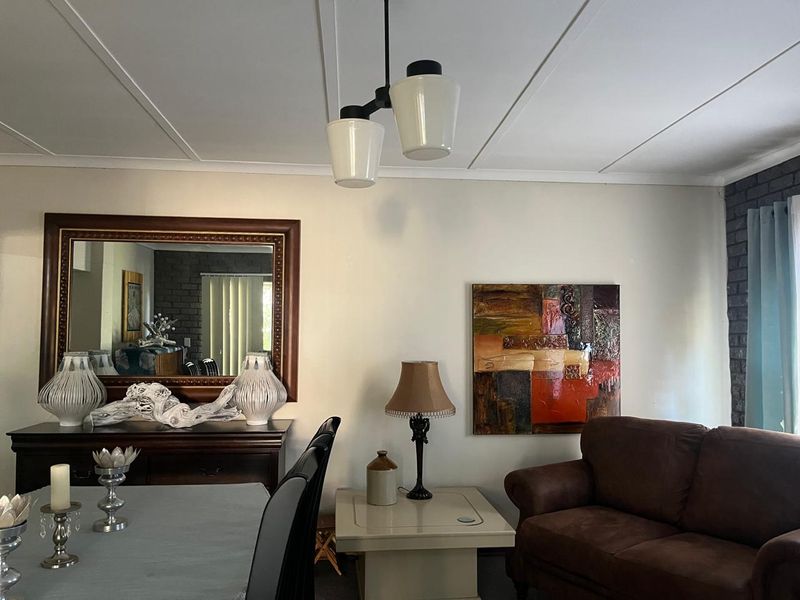 A living room area featuring an exposed brick wall and a central pendant light fixture, providing a functional space for relaxation.