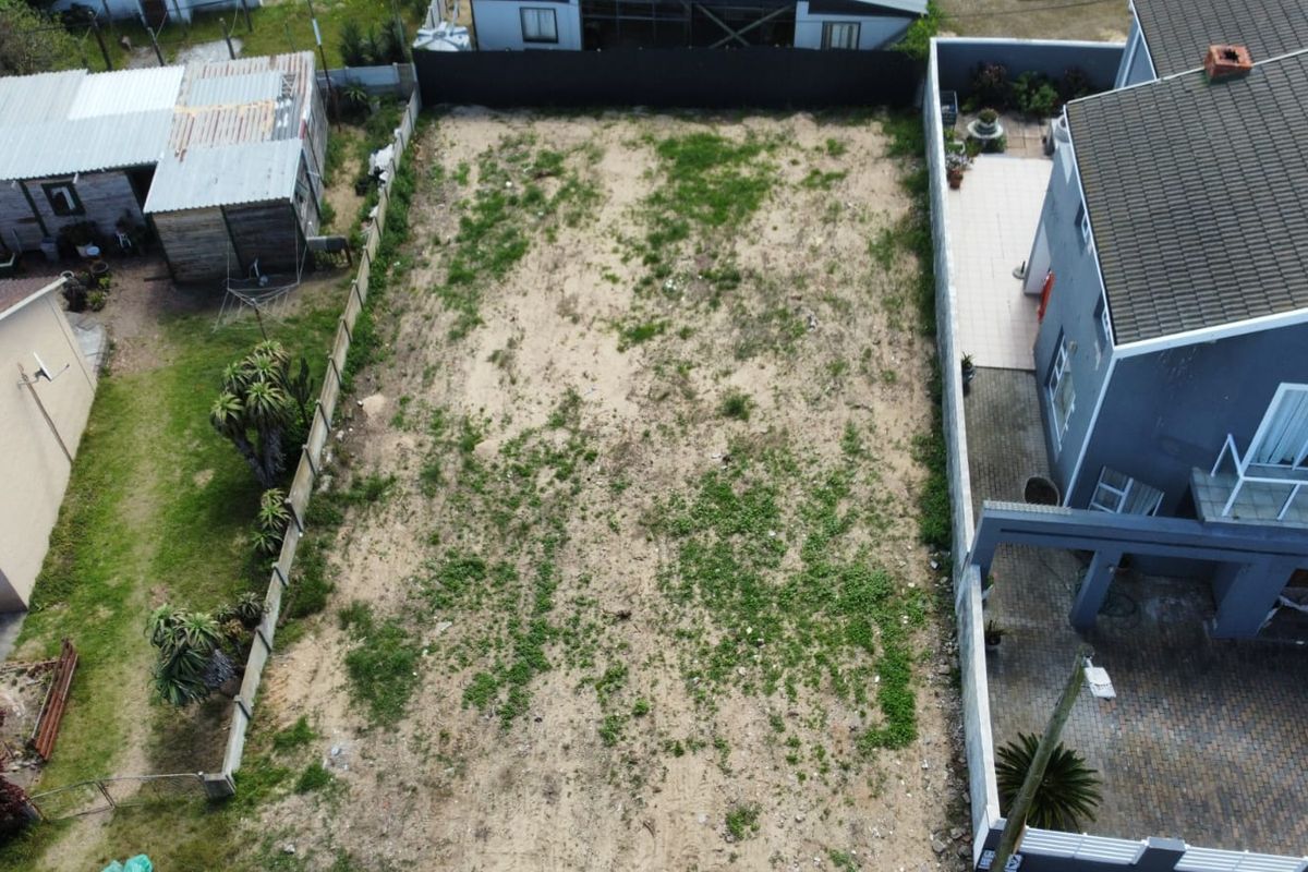 Aerial view of a vacant residential plot situated between existing properties, featuring established boundary fencing and clear access for future development.