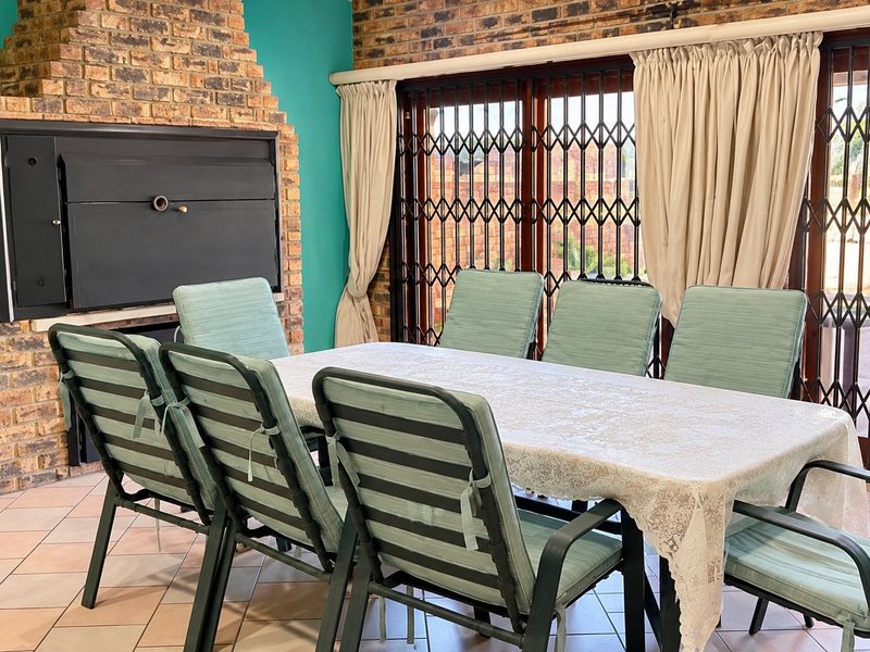 Dining area featuring a built-in brick fireplace, tiled flooring, and sliding glass doors with security gates leading to the exterior.