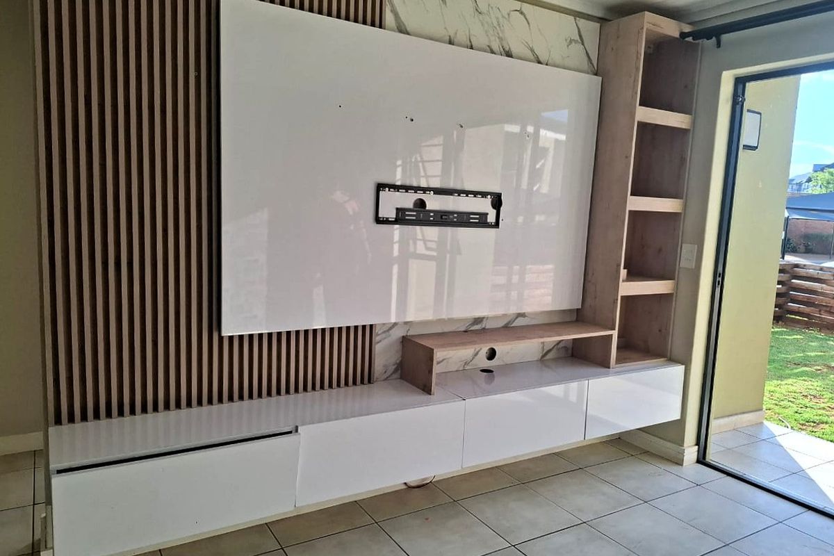 Modern living room featuring a custom built-in media wall with slatted timber accents, marble-effect paneling, and sleek floating cabinetry.