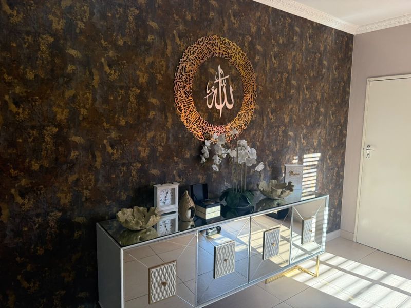 An inviting entrance hall featuring a striking textured feature wall, tiled flooring, and elegant decorative cornice detailing.