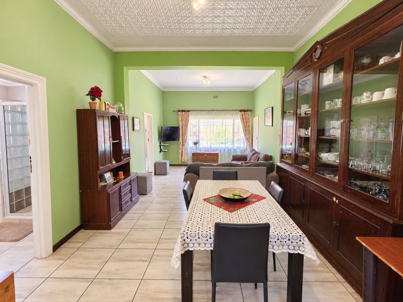 Spacious open-plan living and dining area featuring classic pressed metal ceilings, tiled flooring, and extensive built-in display cabinetry.