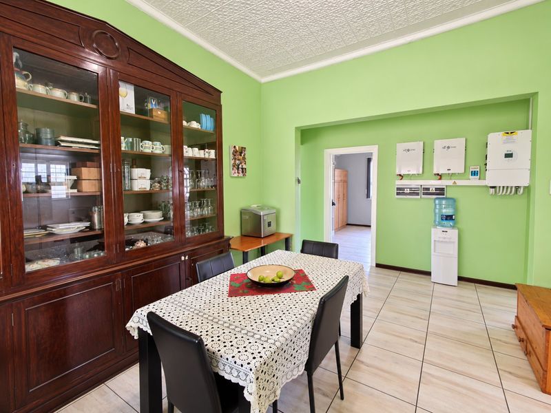 Dining area featuring tiled flooring, a decorative pressed metal ceiling, and wall-mounted solar inverter equipment.