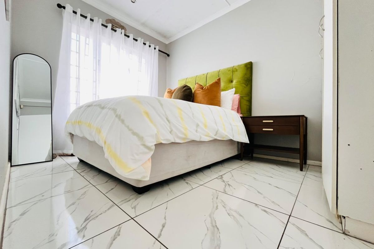 A bedroom featuring marble-look tiled flooring, built-in wardrobe storage, and recessed ceiling lighting.